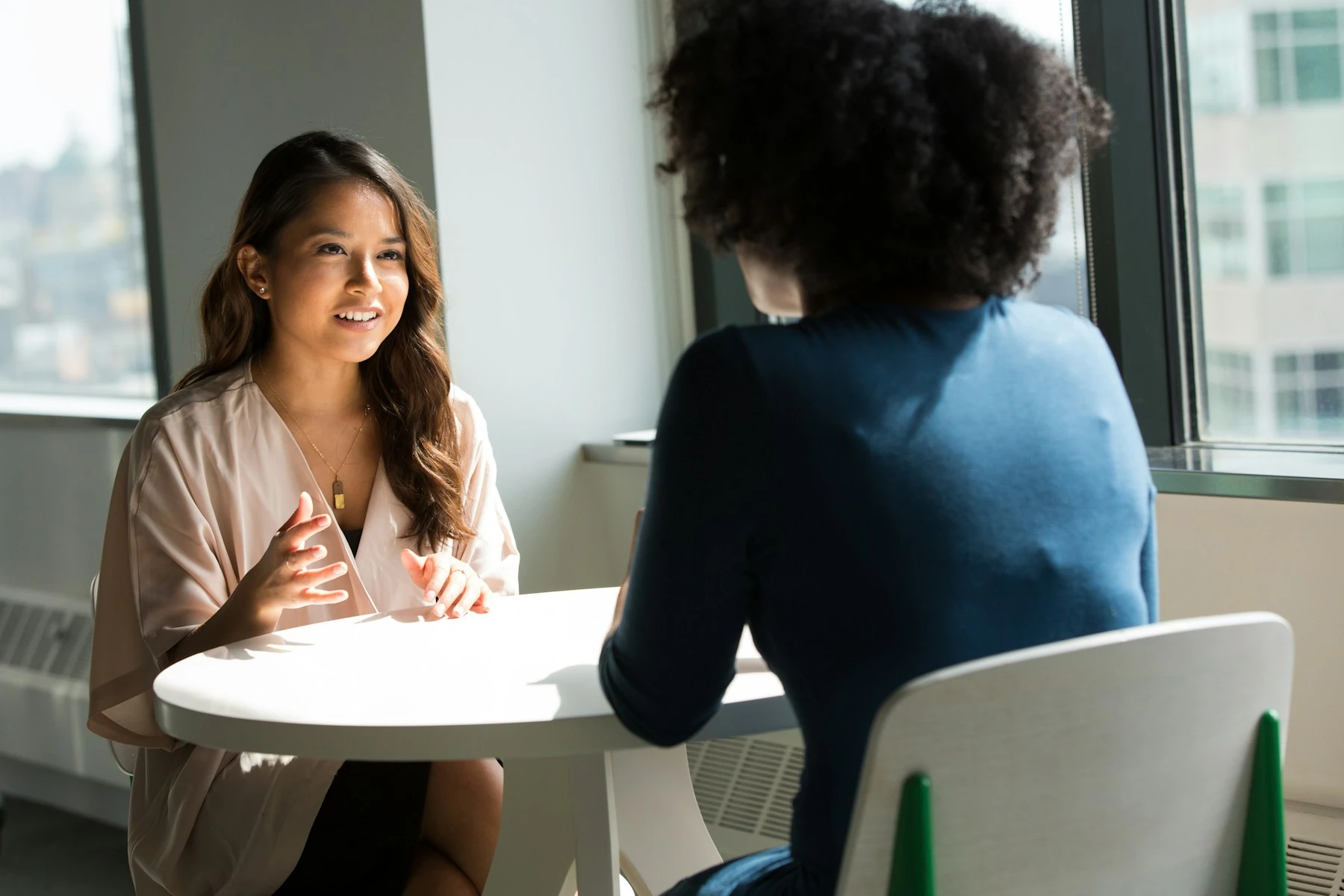 Two colleagues discussing work at a desk