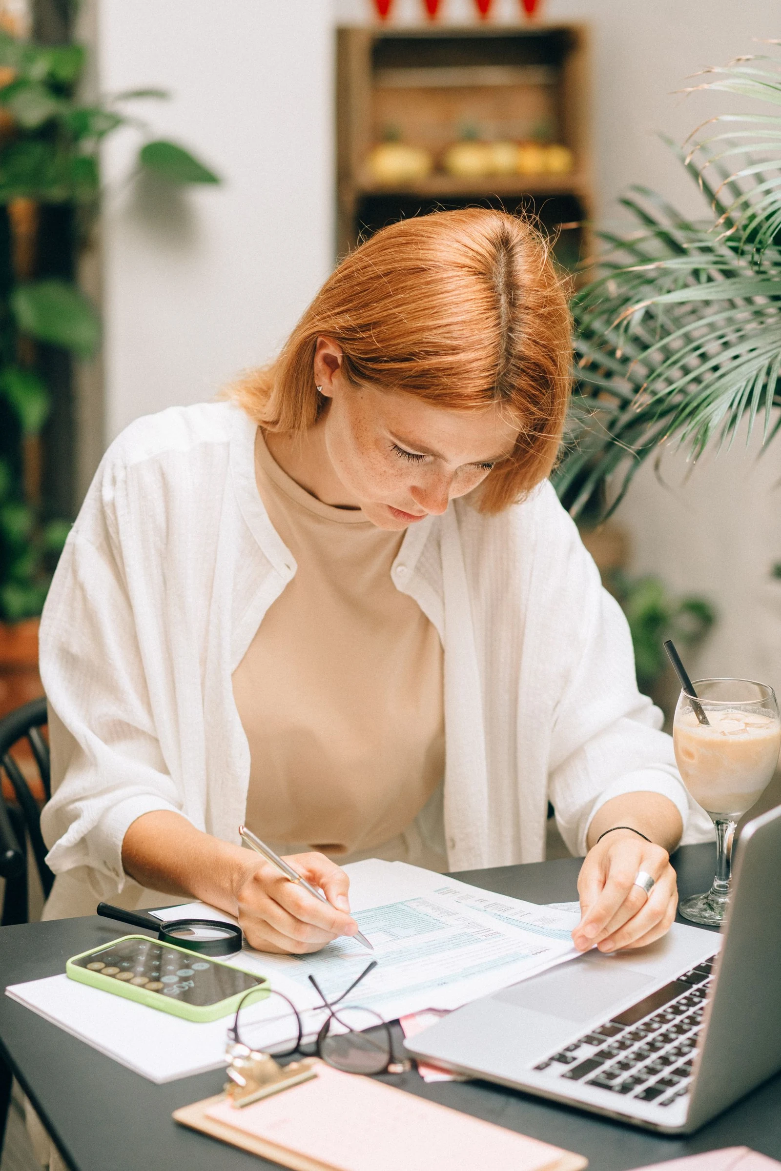 Professional reviewing financial paperwork beside a laptop