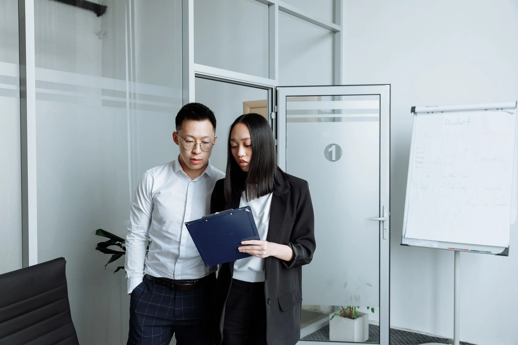 Two colleagues reviewing a folder in an office